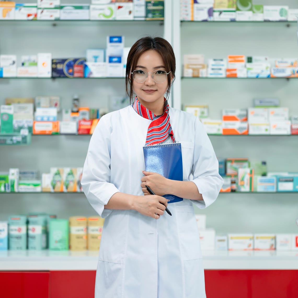 Une pharmacienne devant les rayons de son officine, carnet à la main — photo provisoire