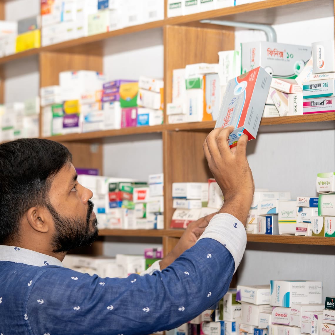 Un pharmacien prend une boîte dans le rayon de son officine — photo provisoire