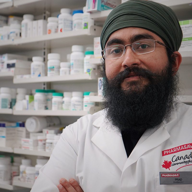 Un pharmacien devant les rayons de son officine