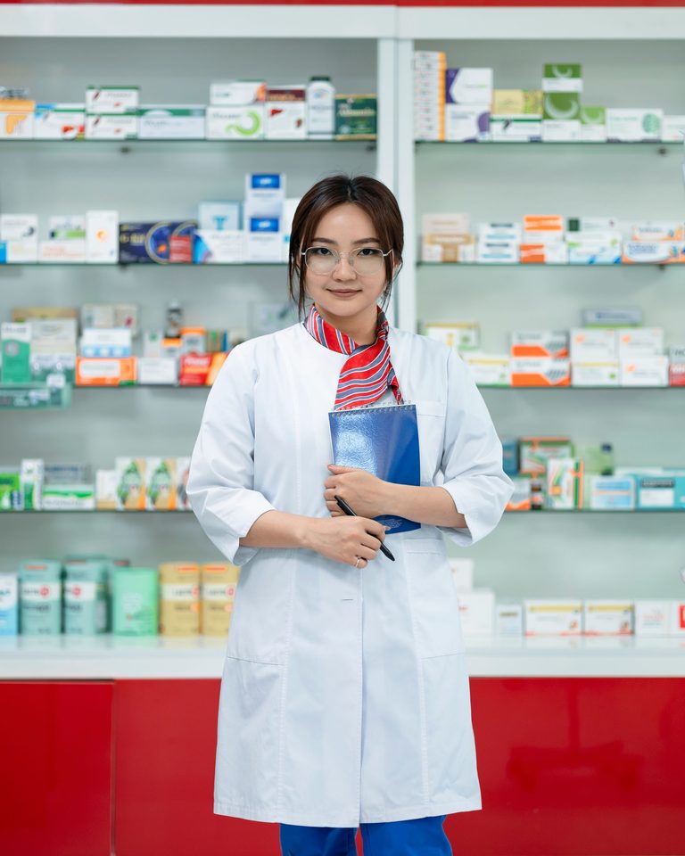 Une pharmacienne dans son officine, un carnet à la main