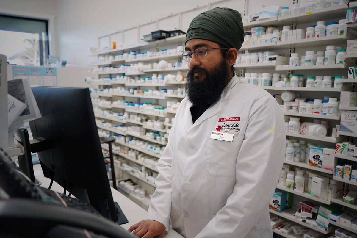 Un pharmacien consulte l’écran de son comptoir