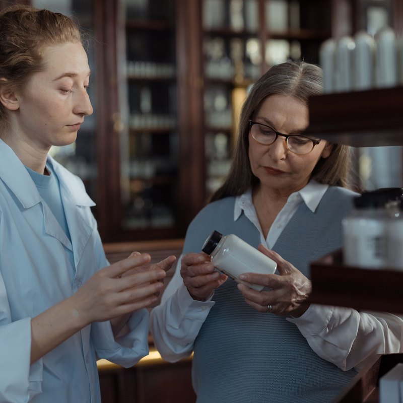 Une cliente et sa pharmacienne examinent un produit au comptoir