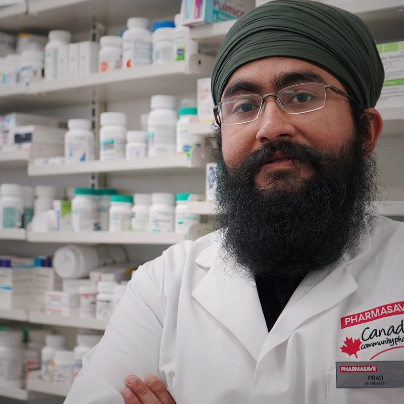 Un pharmacien devant les rayons de son officine