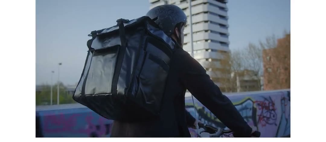Un coursier à vélo en ville, colis sur le dos