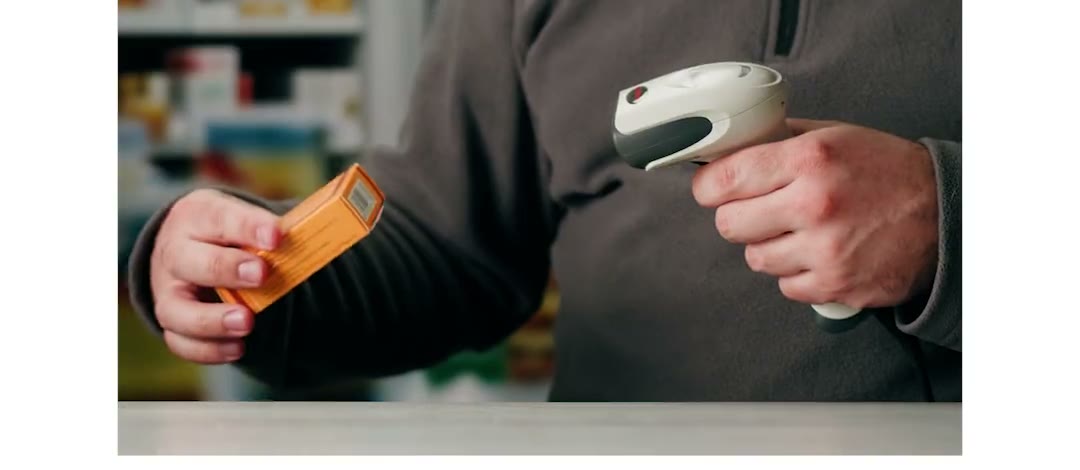 Un pharmacien scanne une boîte au comptoir — vidéo en boucle (capture animée du cockpit Nexum Pro à produire)